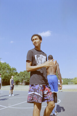 Basketballspieler auf dem Freiplatz reibt sich die Hände mit Blick zur Konkurrenz